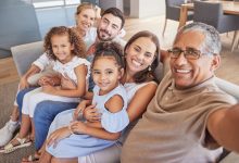 Selfie, family and children with a grandfather taking a photograph of his grandchildren and parents at home. Kids, love and grandparents with a man and his relatives in the living room for a photo.